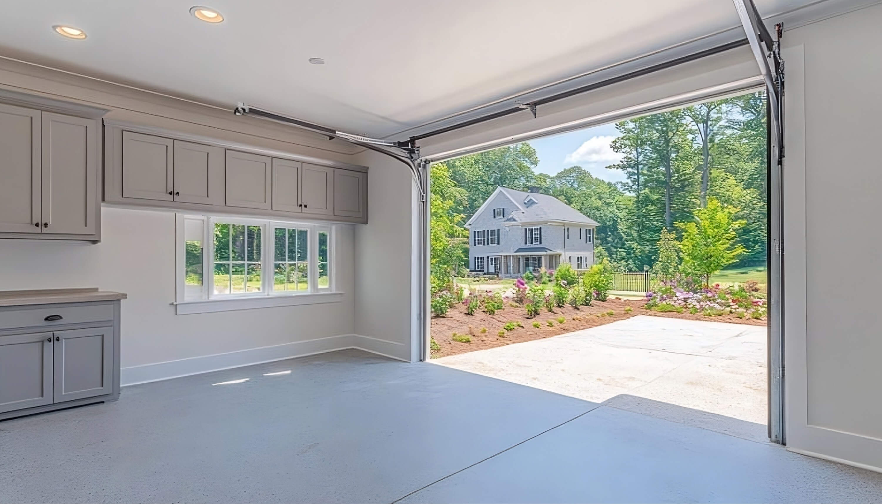 Garage with custom white cabinetry and overhead storage