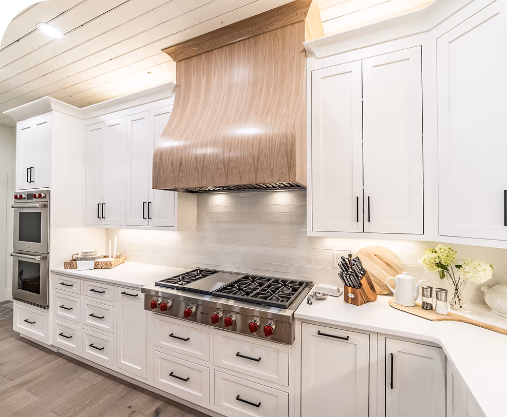 Luxury kitchen with white cabinets and wood range hood