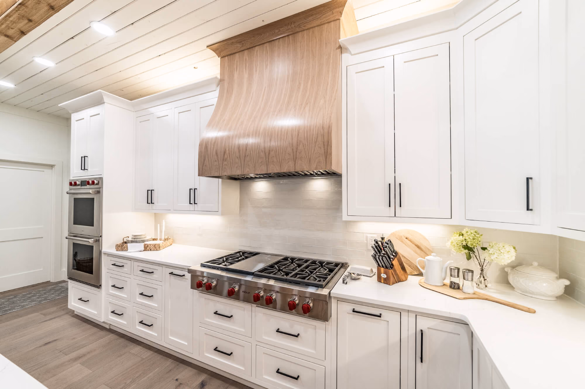 Two-tone kitchen cabinetry with white uppers and wood accents