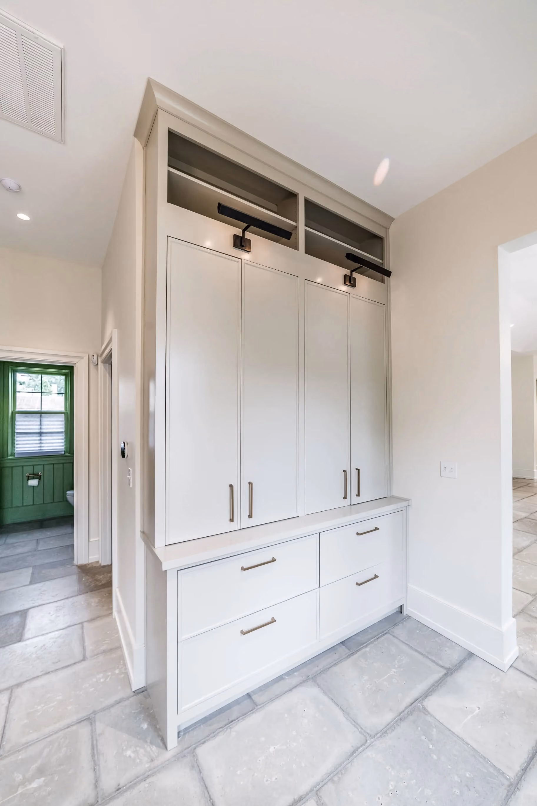White mudroom cabinets with coat hooks and storage bench