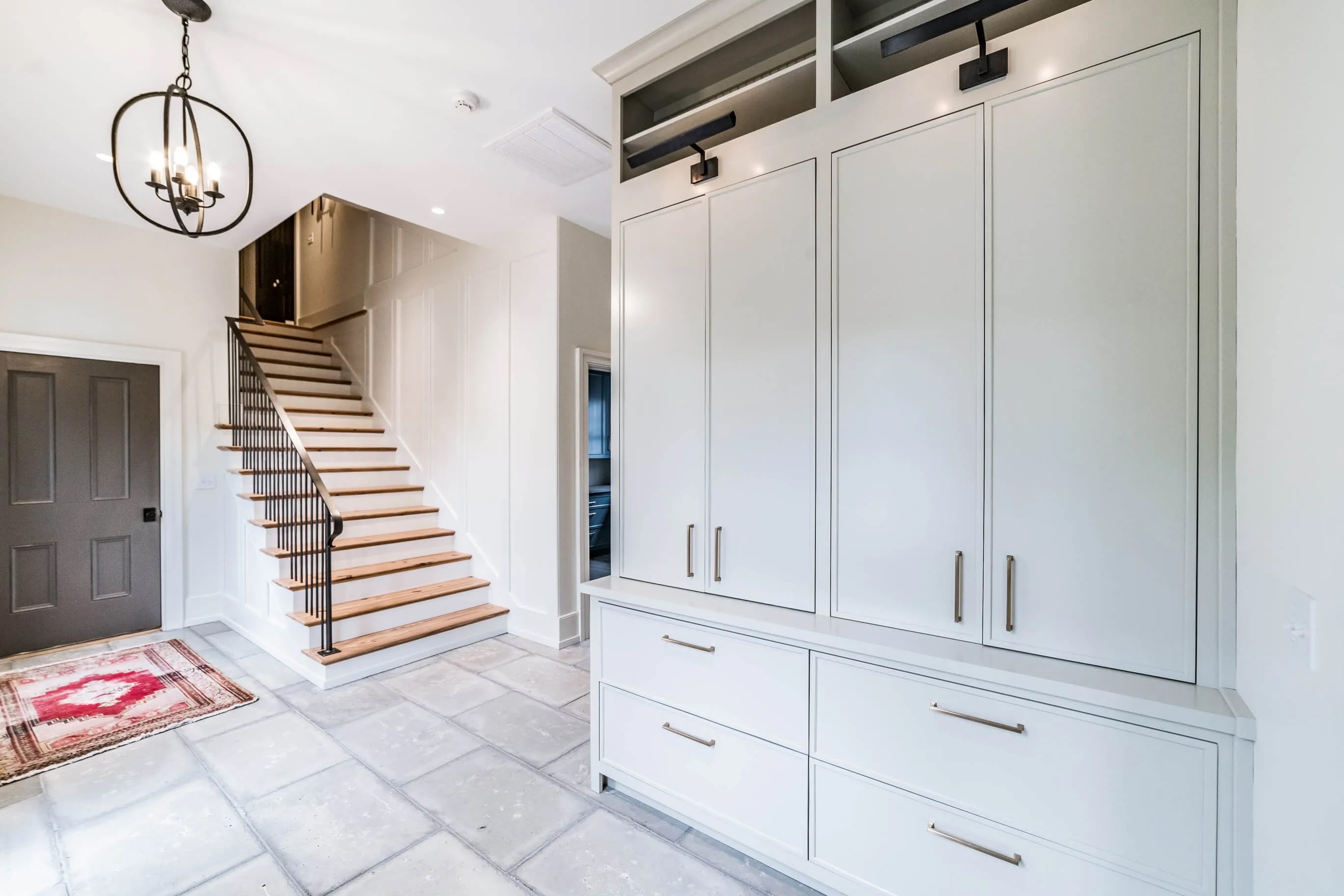 Mudroom with tall white custom cabinetry and paneling