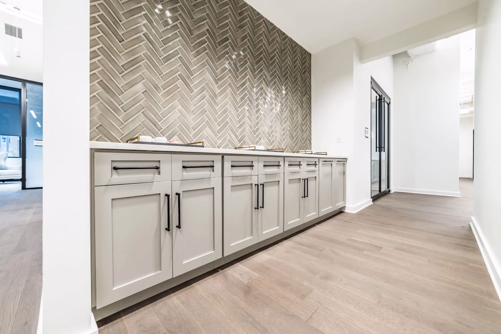 Modern office kitchenette with light gray cabinets.