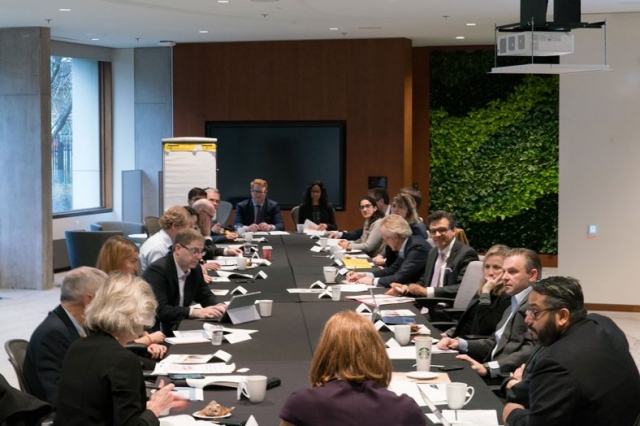 Participants sitting around a large meeting table at the Century Initiative quarterly meeting
