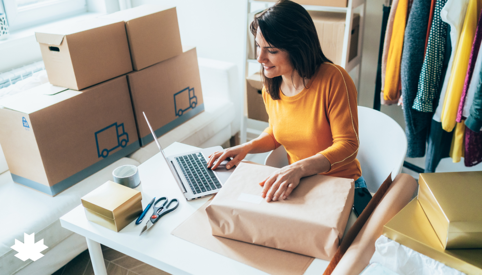 Young woman sitting at a table on their laptop preparing shipments.