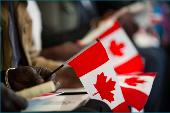 New Canadian citizens and their flags during a citizenship ceremony.