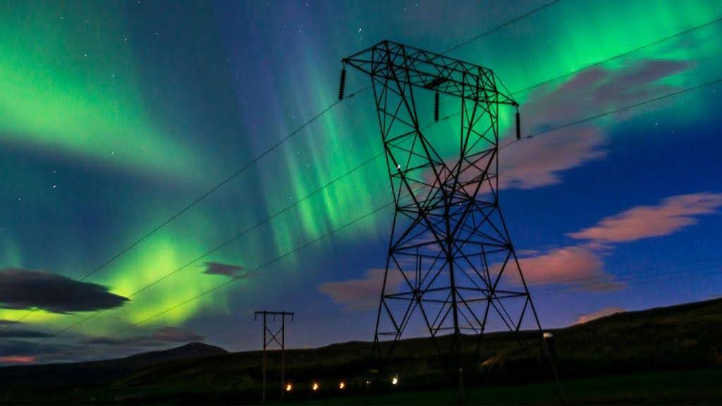 Power lines with the northern lights behind.