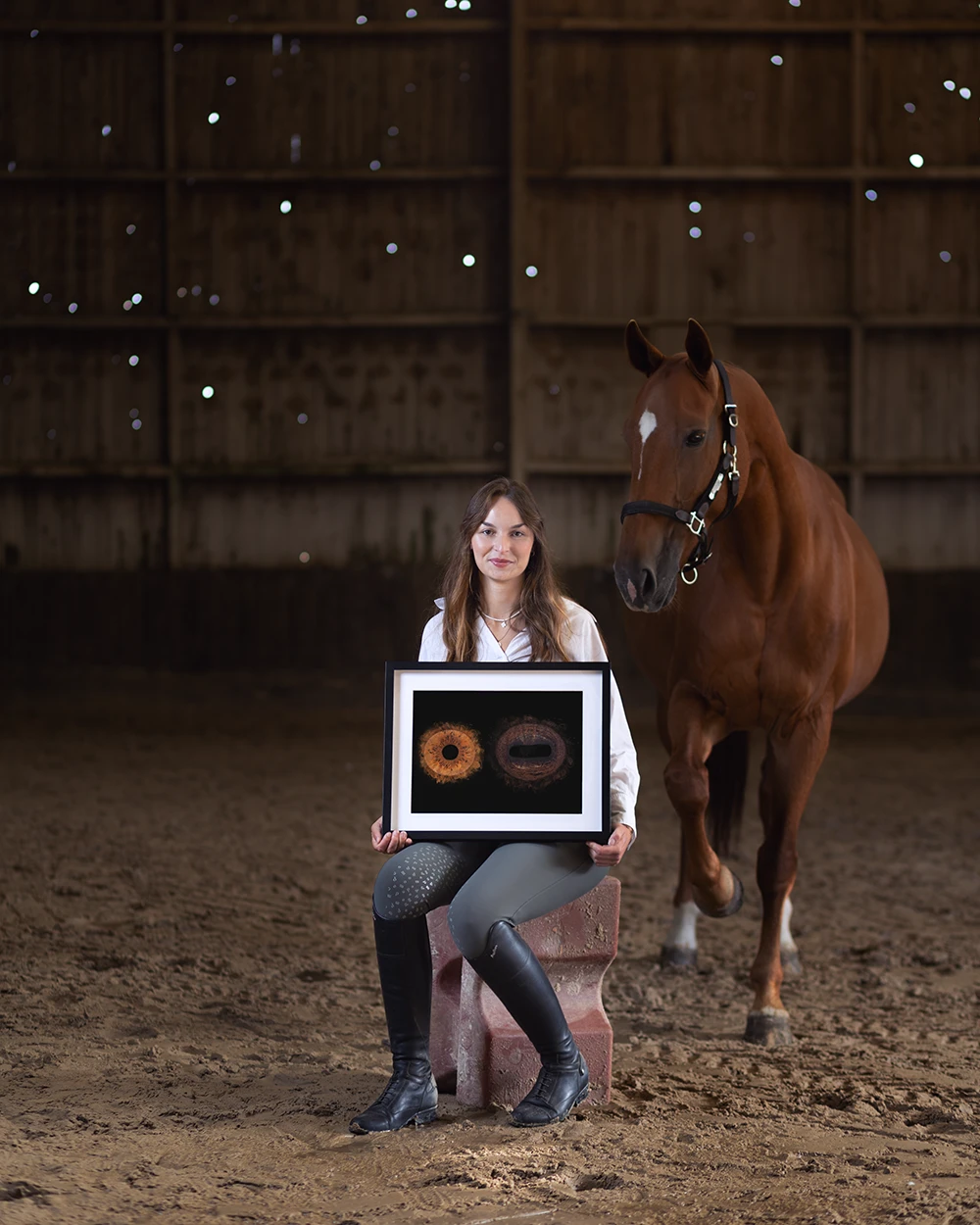 Photographie d’une cliente équestre, fière de son tirage d’art INTO THE EYES aux côtés de son cheval.