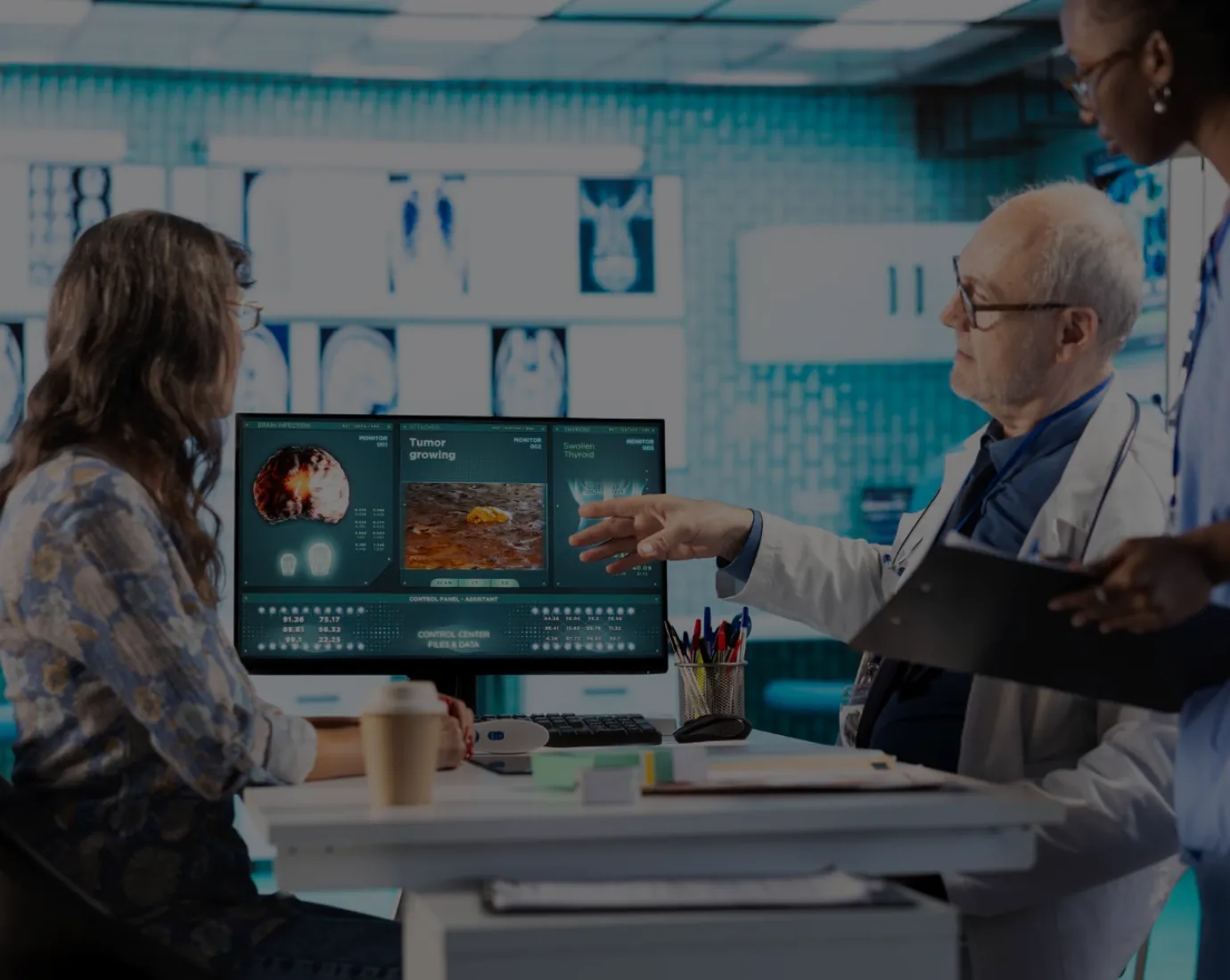 A group of people standing around a computer screen.