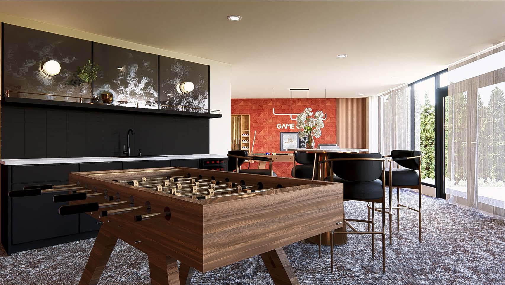 Modern games lounge with a foosball table, black cabinetry, round dining table with black chairs, and a red feature wall with the word “GAME” displayed. Floor-to-ceiling windows bring in natural light.