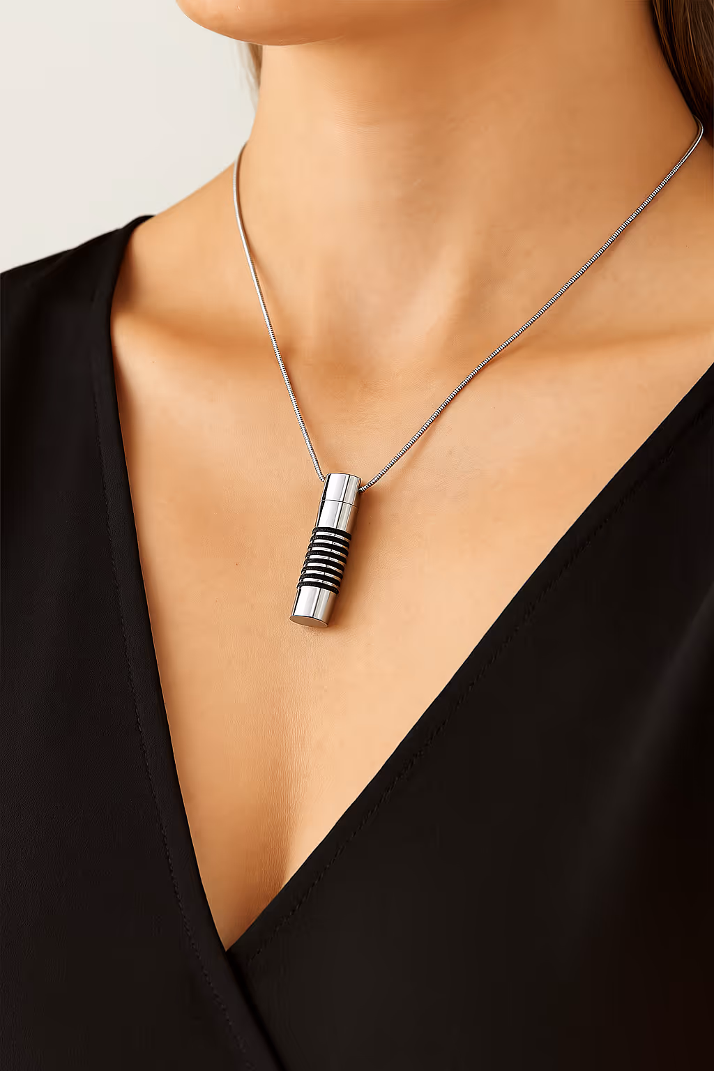 Un collar relicario para almacenar cenizas con forma de cilindro stripes.