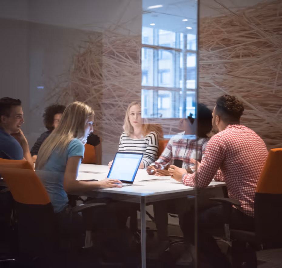 A group of people sitting at a table in a meeting room