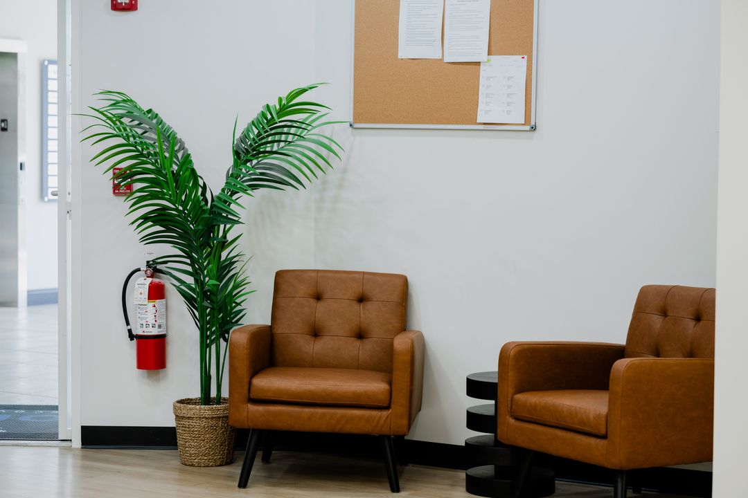 Seating area with brown chairs and a plant at Robin Recovery's Cleveland-area facility