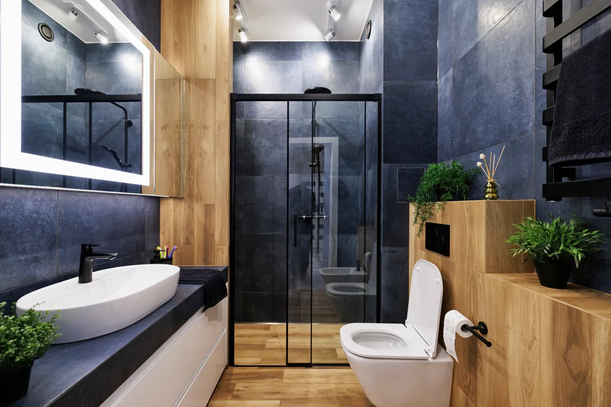 Contemporary bathroom remodel in Burlington featuring large-format porcelain tiles, warm oak vanity accents, and black-framed glass shower by Leo Constra