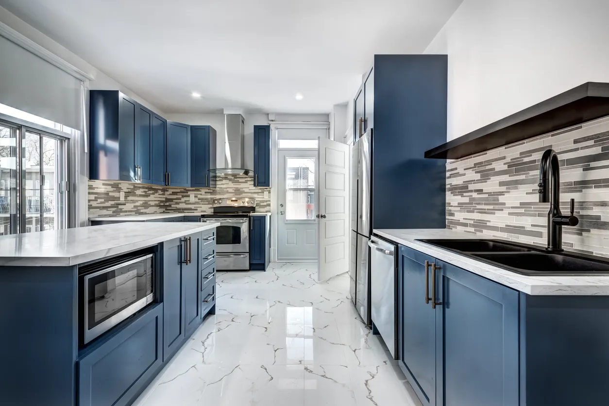 Modern kitchen renovation featuring custom blue cabinetry, marble countertops, and smart storage solutions in Ontario by Leo Constra