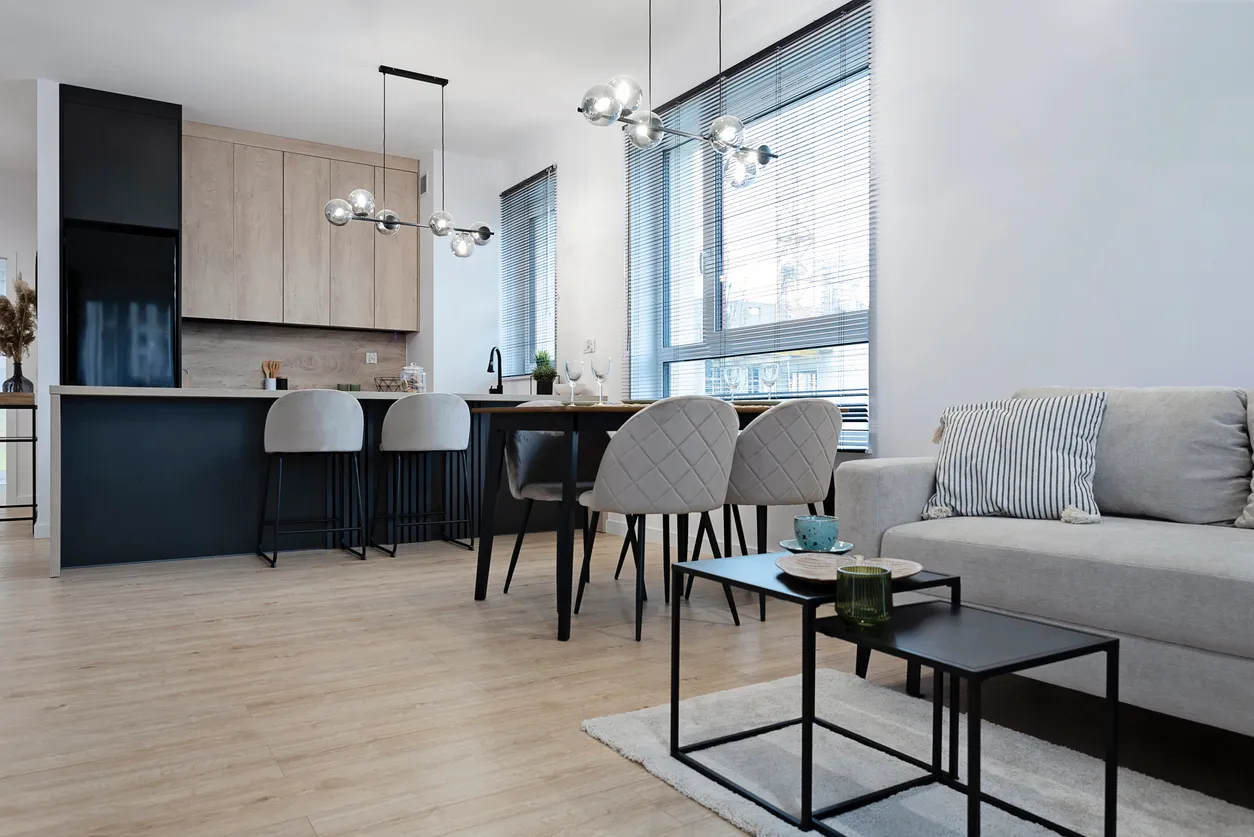 Contemporary condo renovation with open-concept kitchen and living area, modern pendant lighting, light wood cabinets, and space-maximizing design in Toronto GTA