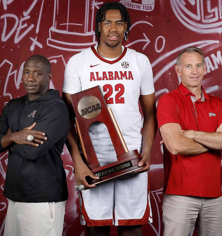 T. J. St. Louis in an Alabama jersey holding the NCAA regional champions trophy between two men