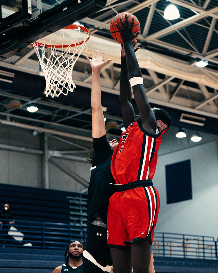 FEIA senior boys basketball player in a red uniform rising to block a shot at the rim