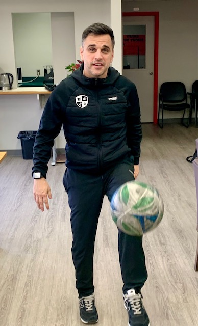 Aleks Balta juggling a soccer ball indoors