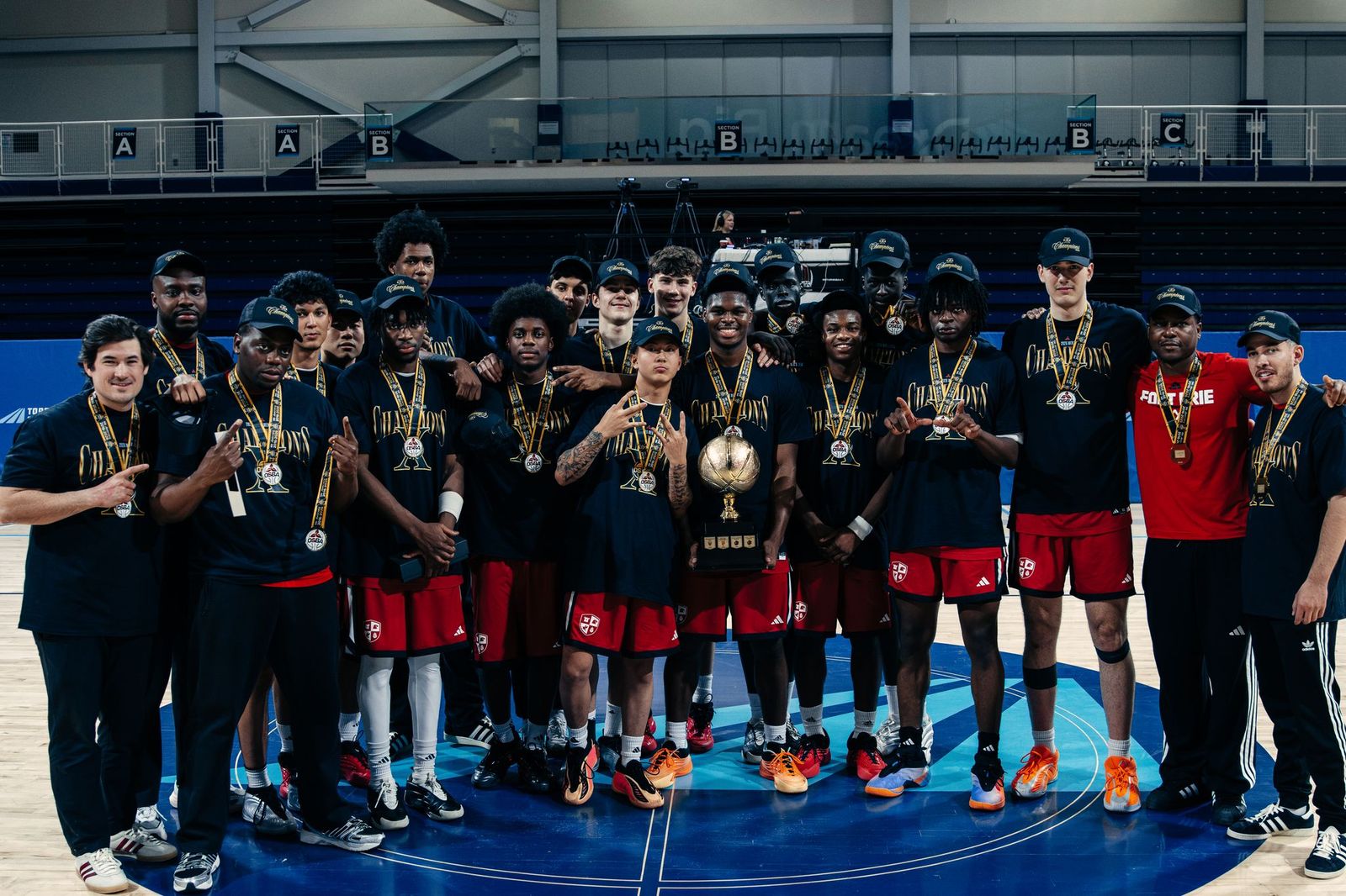 FEIA Falcons basketball team posing with medals and a trophy after winning the OSBA championship