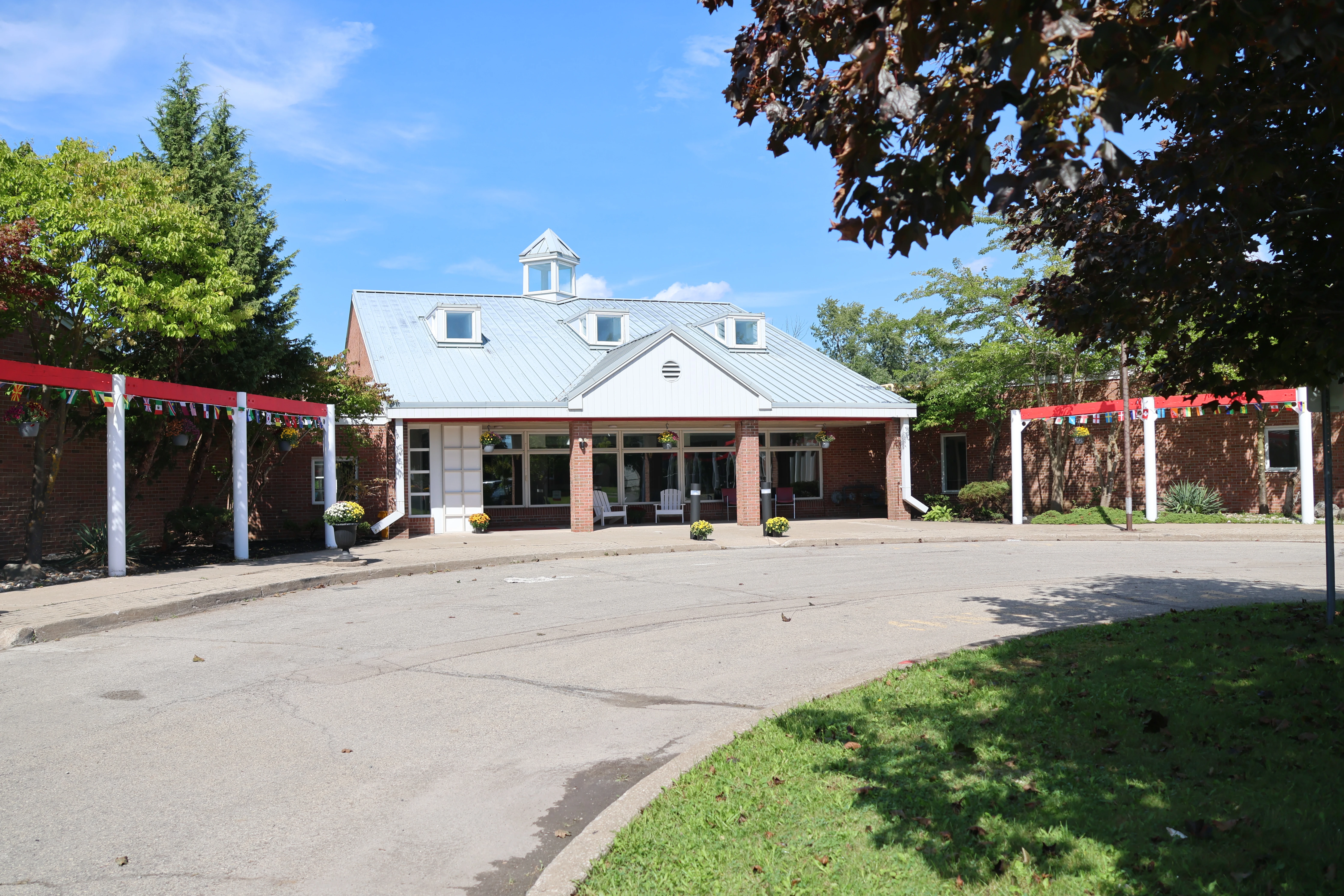 FEIA Village residence building and entrance framed by red pergolas on a sunny day