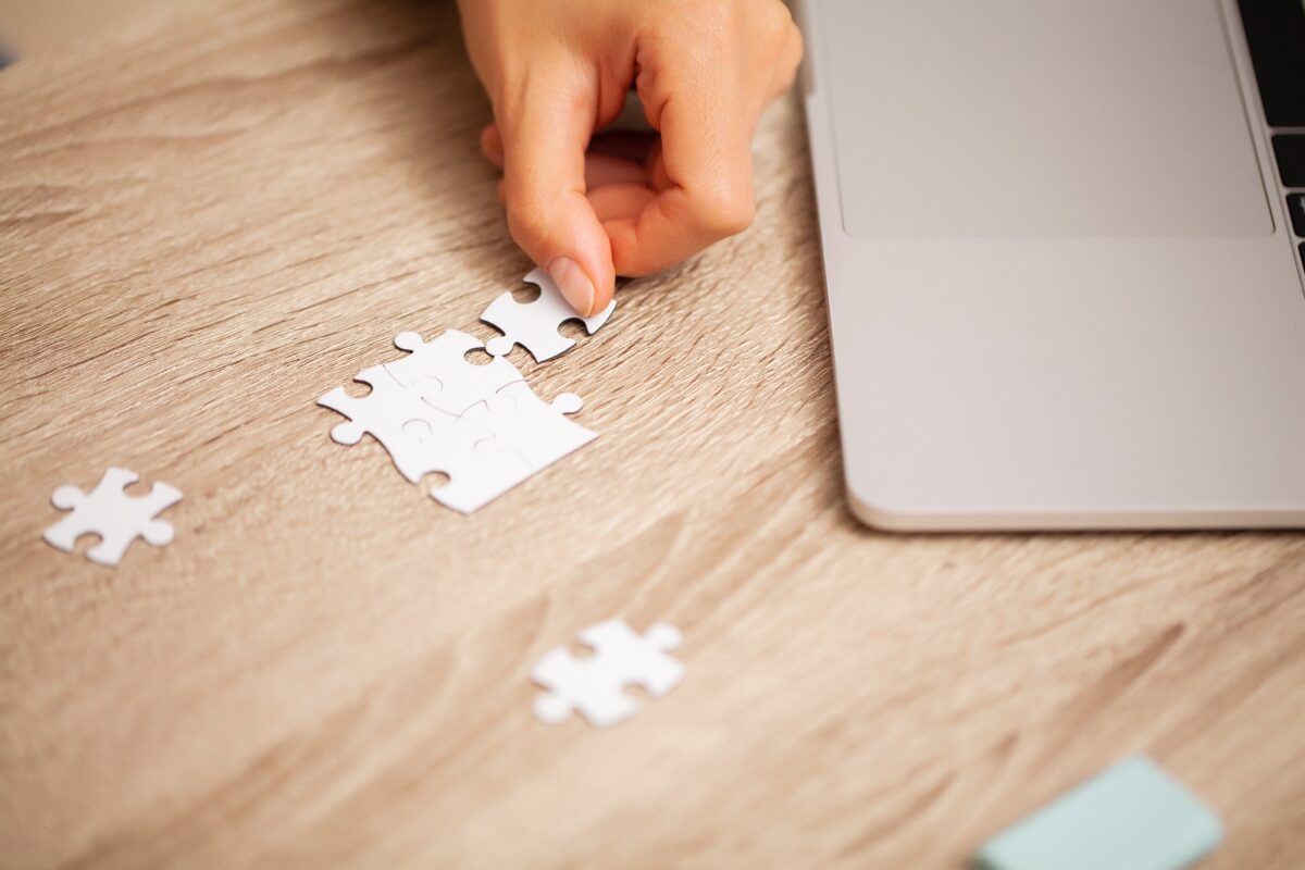 Ilustrasi laptop dengan puzzle, melambangkan plug-in sebagai ekstensi perangkat lunak. Artikel membahas pengertian dan jenis plug-in selain CMS WordPress.