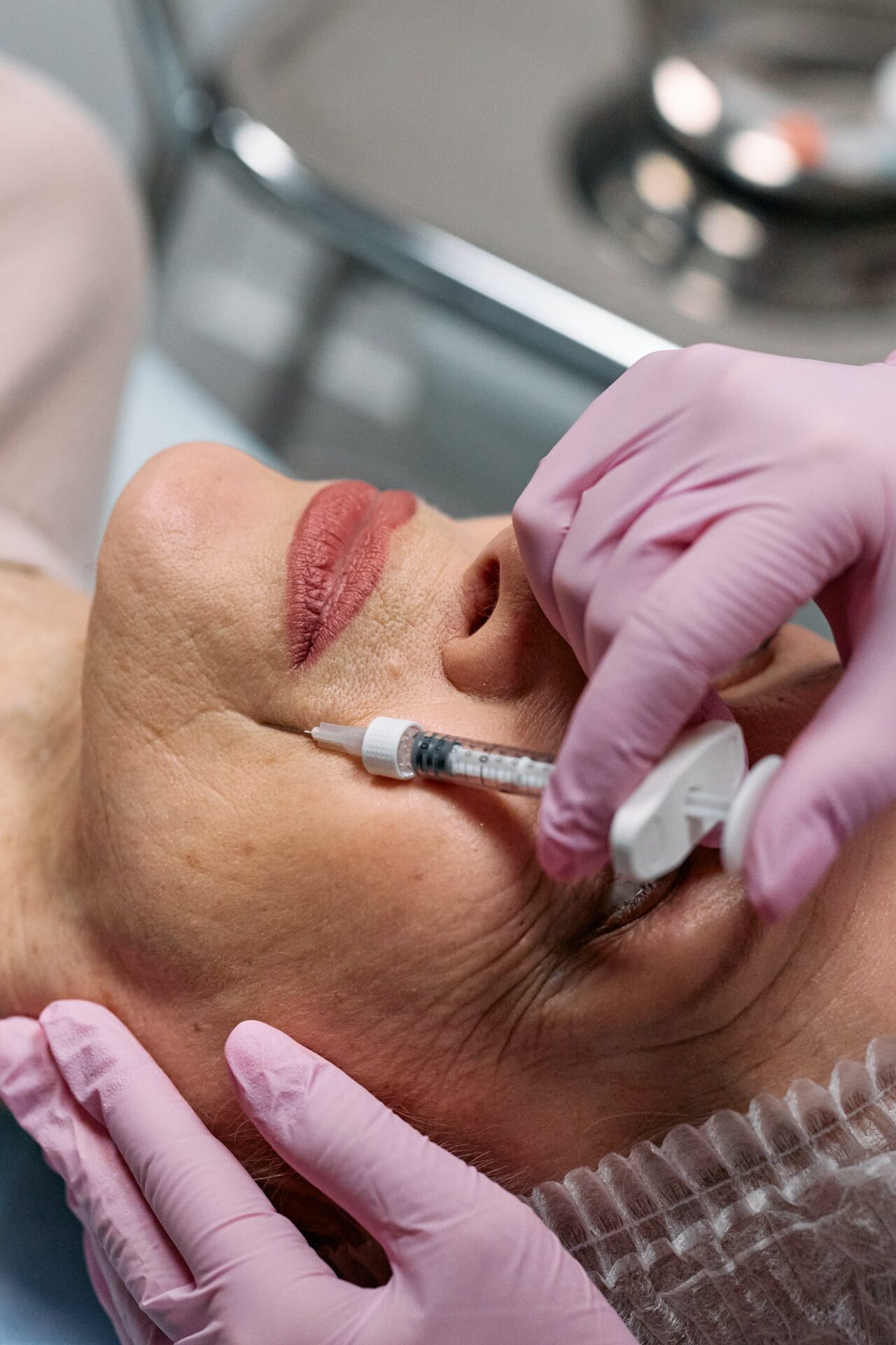 A beginner's guide to cosmetic injectables featuring a woman receiving a facial injection at a clinic.