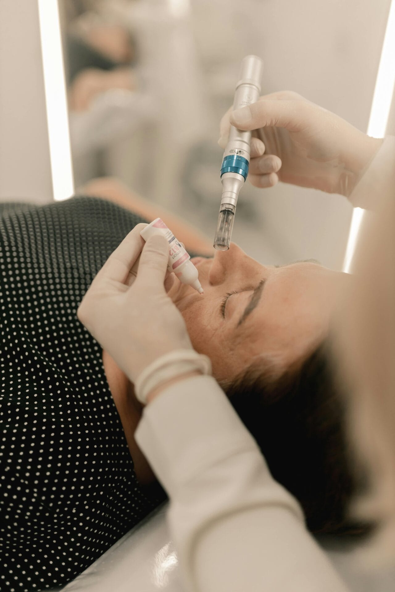 In the serene ambiance of a MedSpa, a person receives a microneedling facial treatment while lying down, the practitioner wearing gloves and expertly using a handheld device.