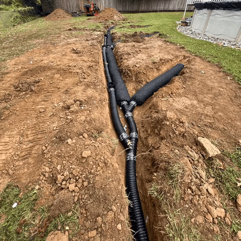drain and pipe being buried for french drain installation near me