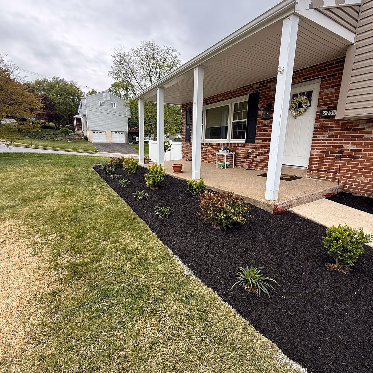Custom garden bed installation with flowers, shrubs, and mulch by E&J Landscaping