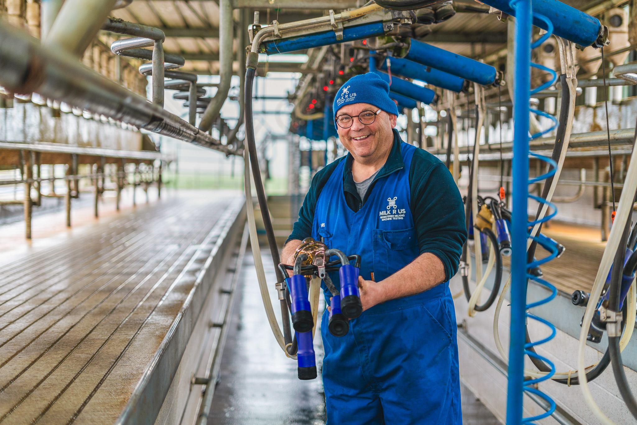 Milk R Us Rep in milking shed showing Milk R Us product