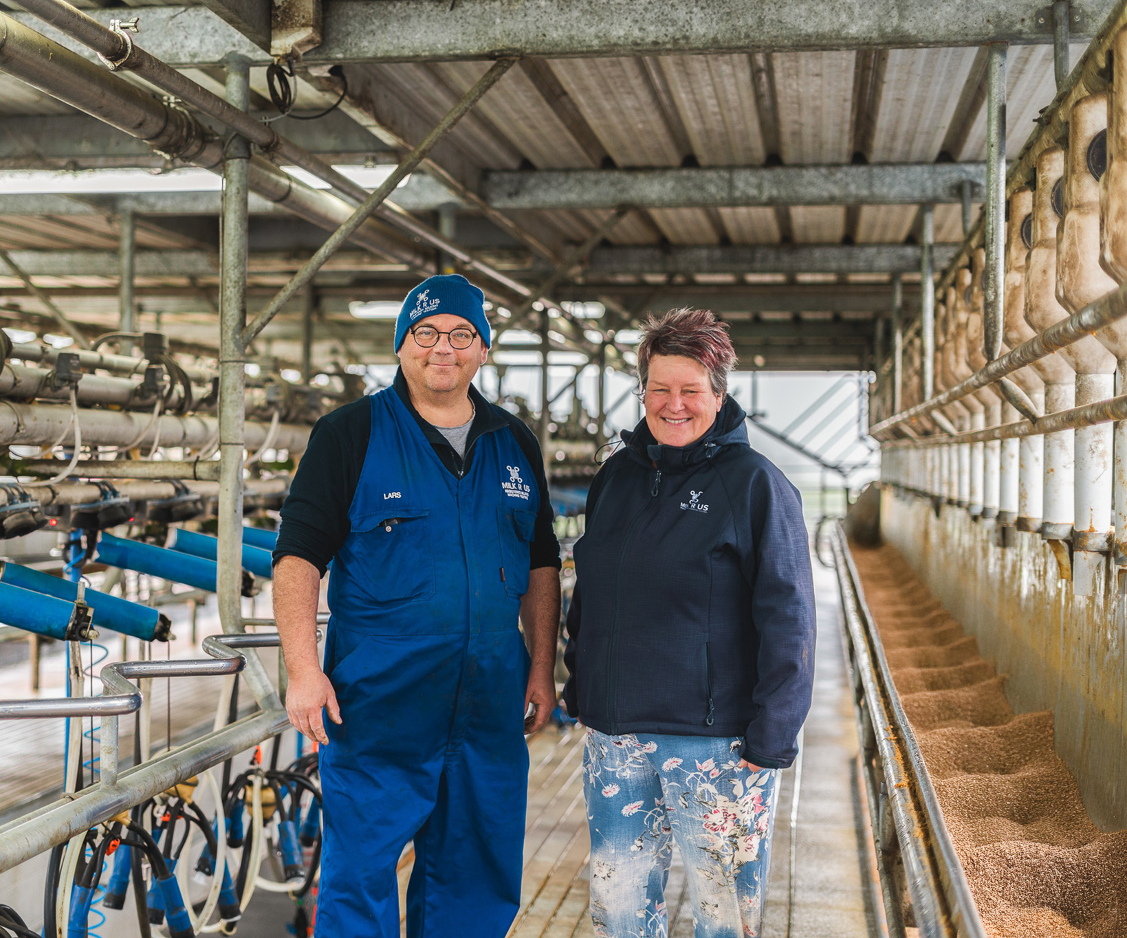 Owners of Milk R Us standing in a milking shed, Lars and Inge
