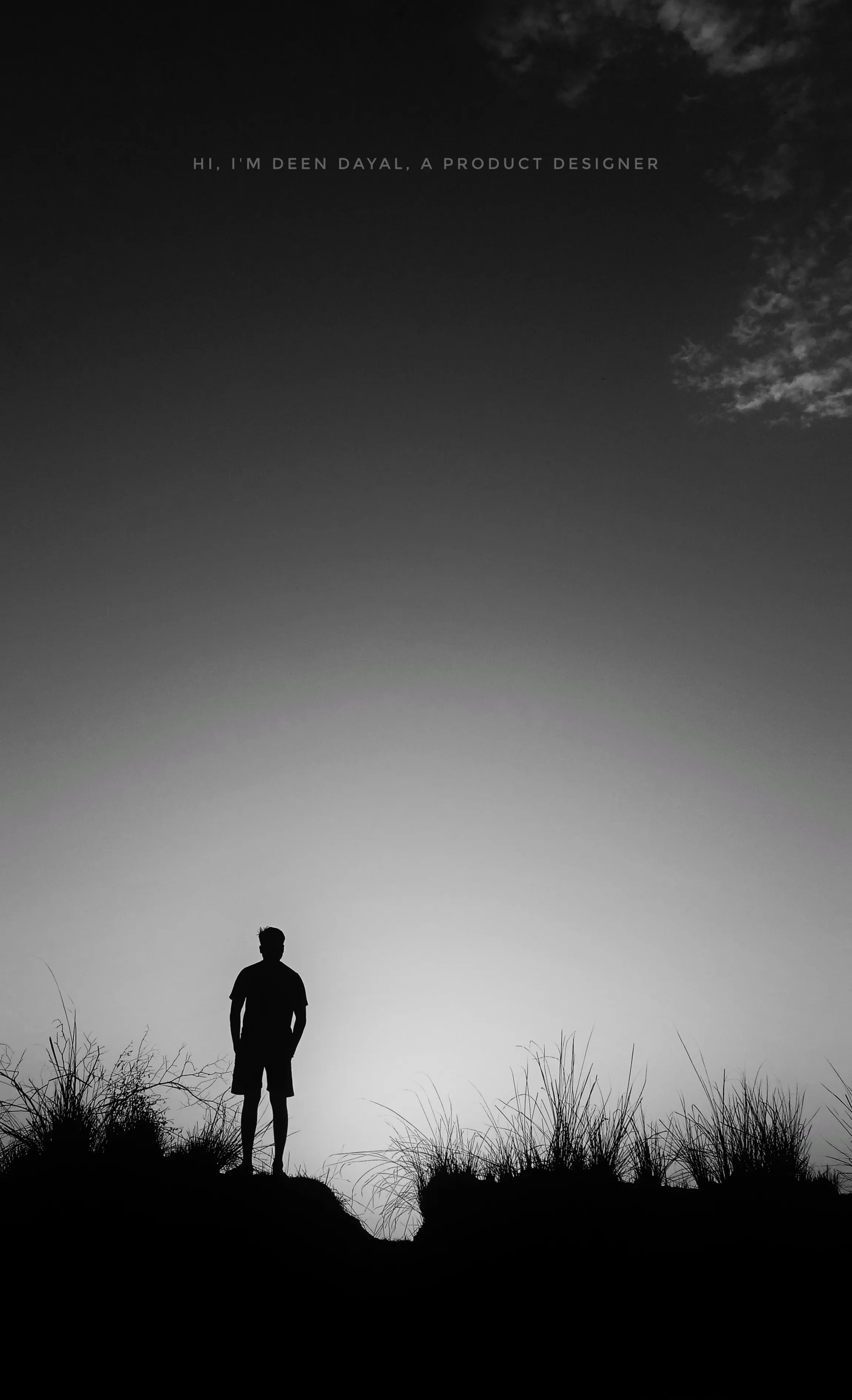 Silhouette of a person standing on a grassy hill under a cloudy sky with text above reading 'Hi, I'm Deen Dayal, a product designer'.