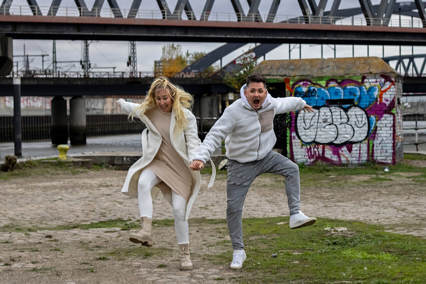 Ein Paar hat Spaß und springt zusammen hoch.