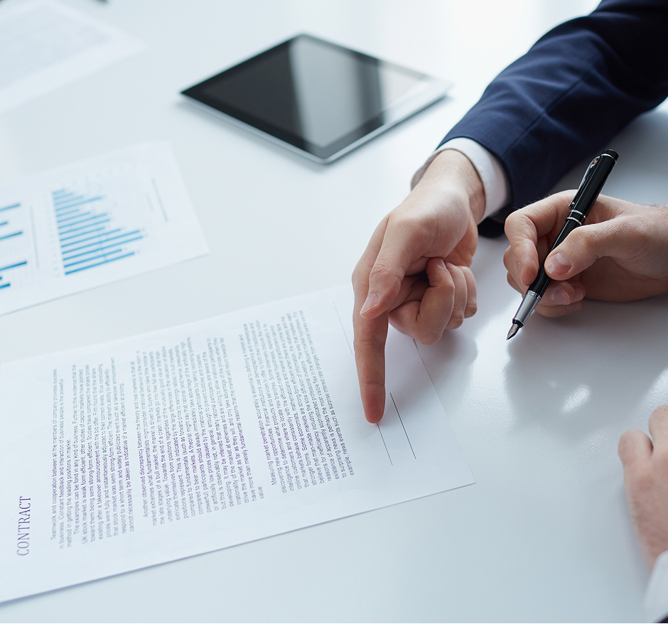 Two professionals discussing printed documents at desk