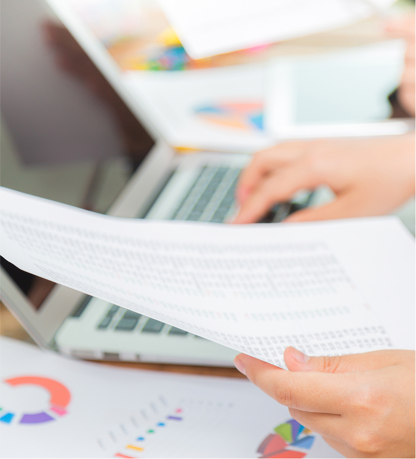 Person reviewing printed business report with charts