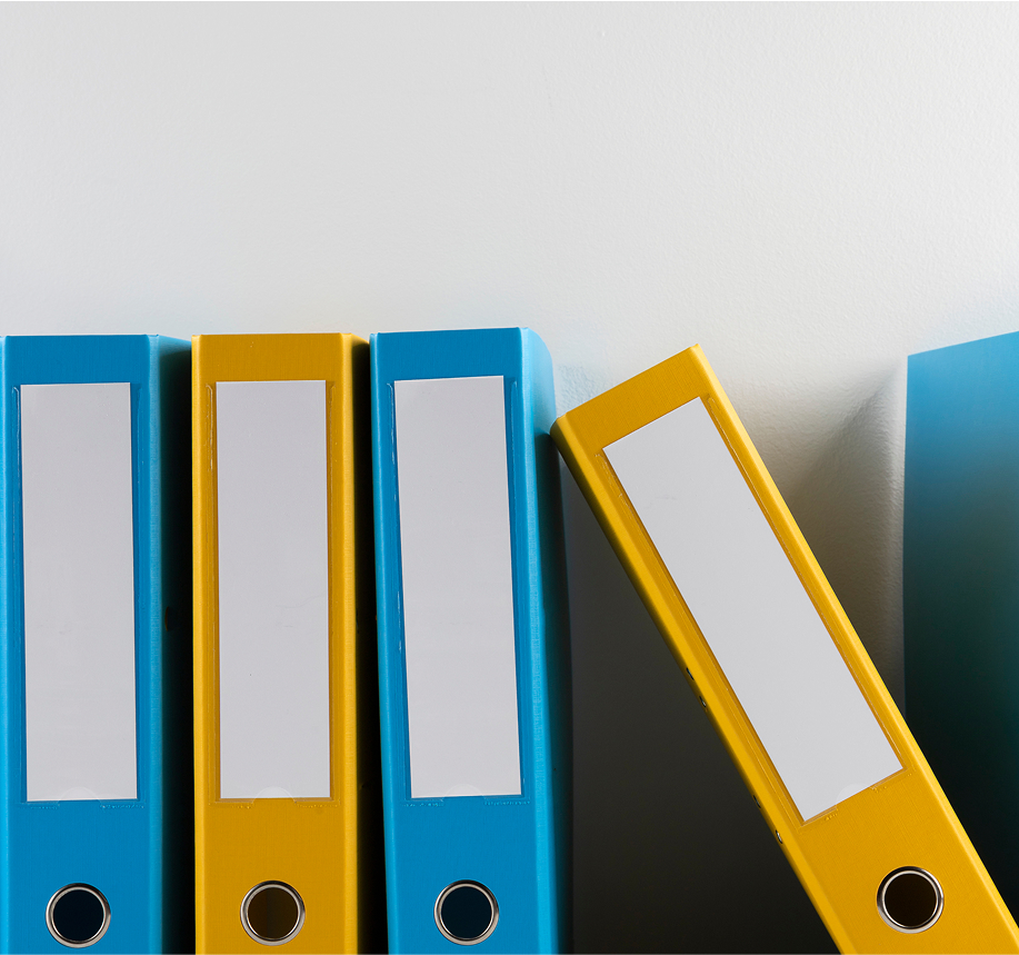 Colorful binders and folders arranged on office shelf
