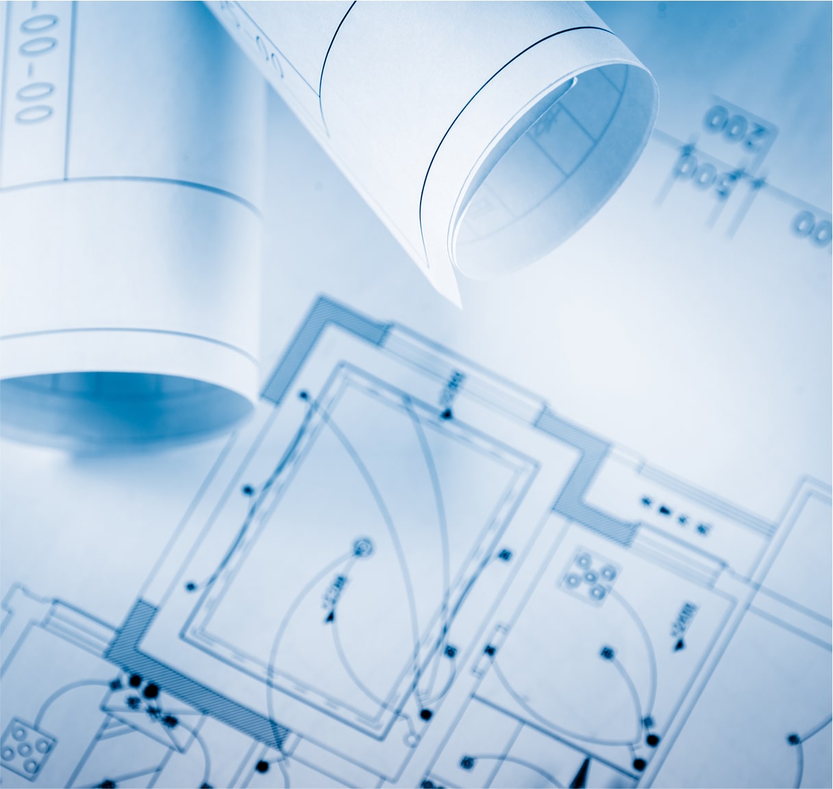 Blueprint documents and architectural plans rolled out on desk