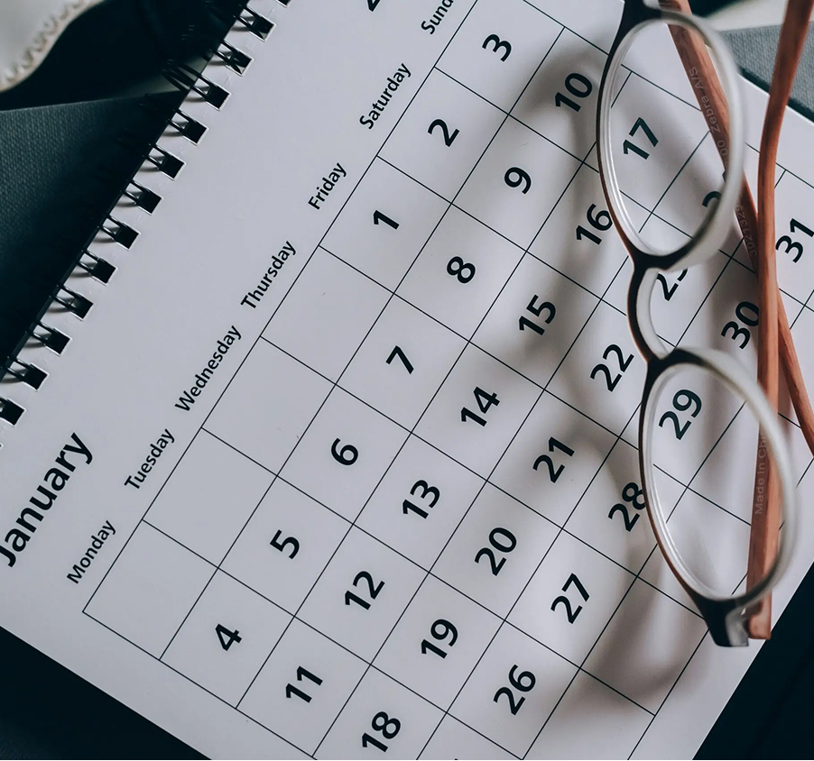 Close-up of calendar planner with glasses on desk