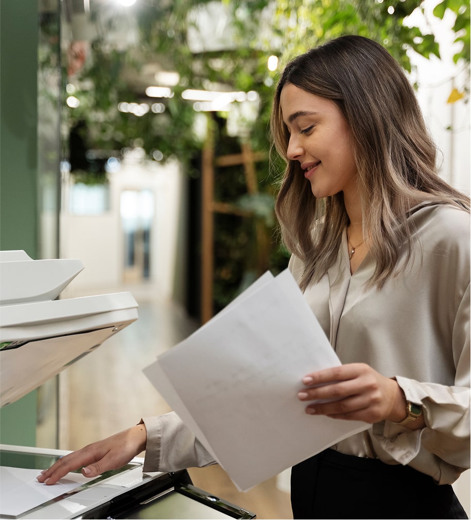 Smiling woman scanning and processing office documents
