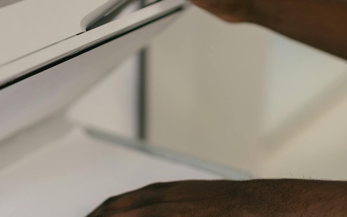 Person placing a legal size document on a flatbed scanner, demonstrating how to scan large paper documents efficiently.