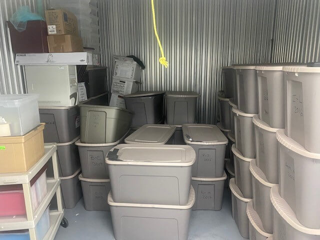 Bins in a storage unit filled with documents