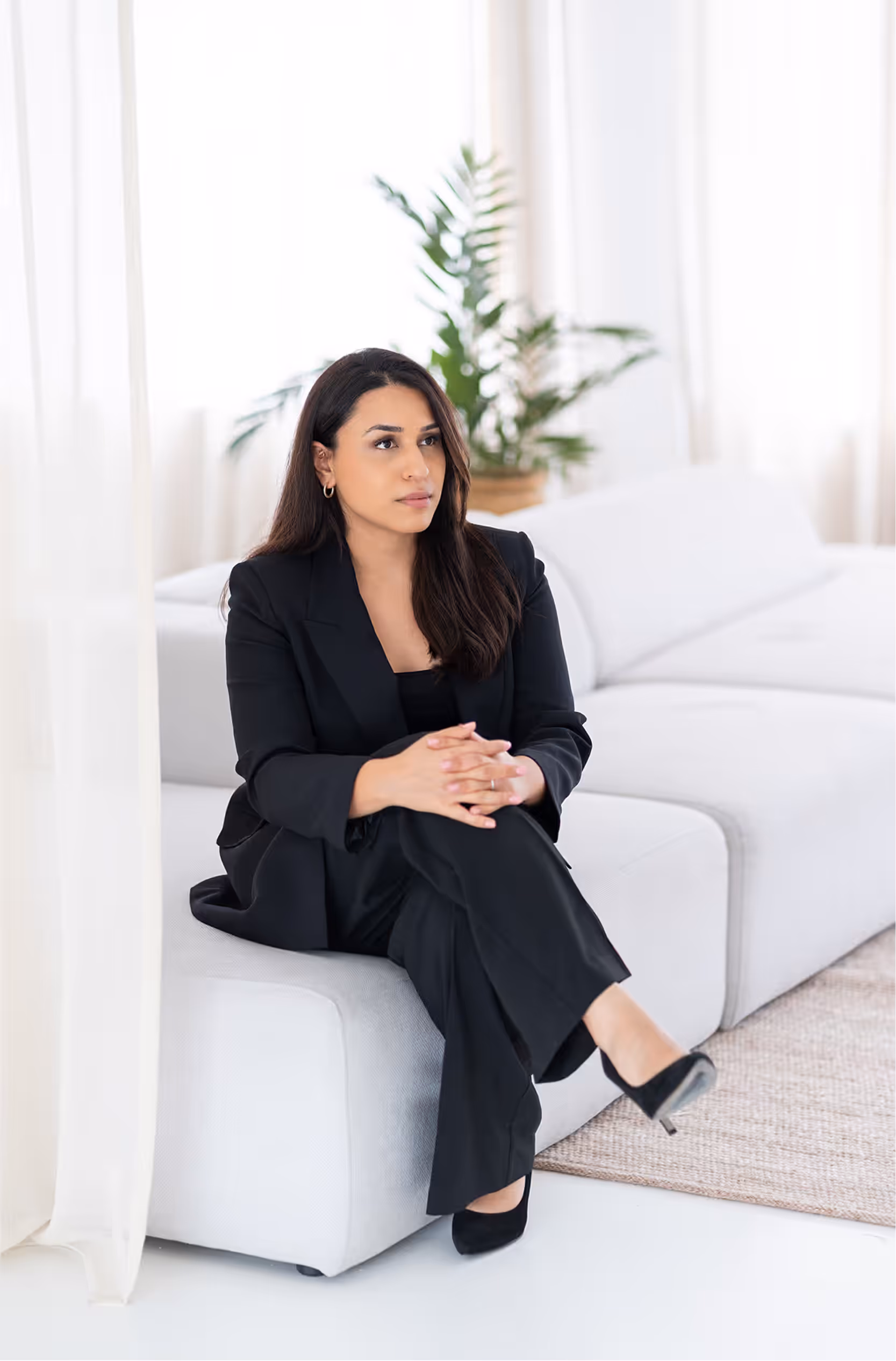 Tahmina Azizi zittend op lichte bank in lichte omgeving