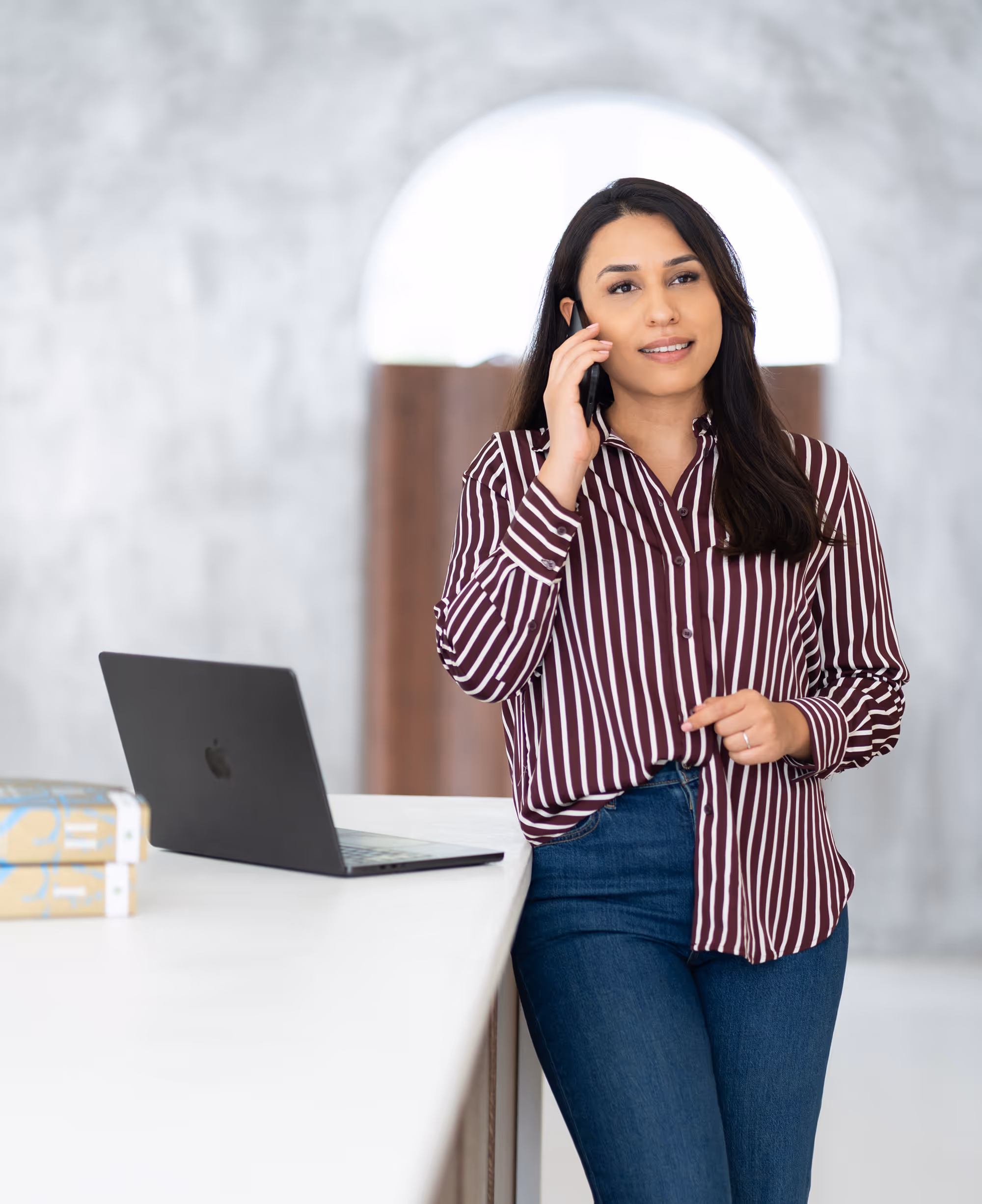 Tahmina Azizi bellend aan de telefoon met laptop