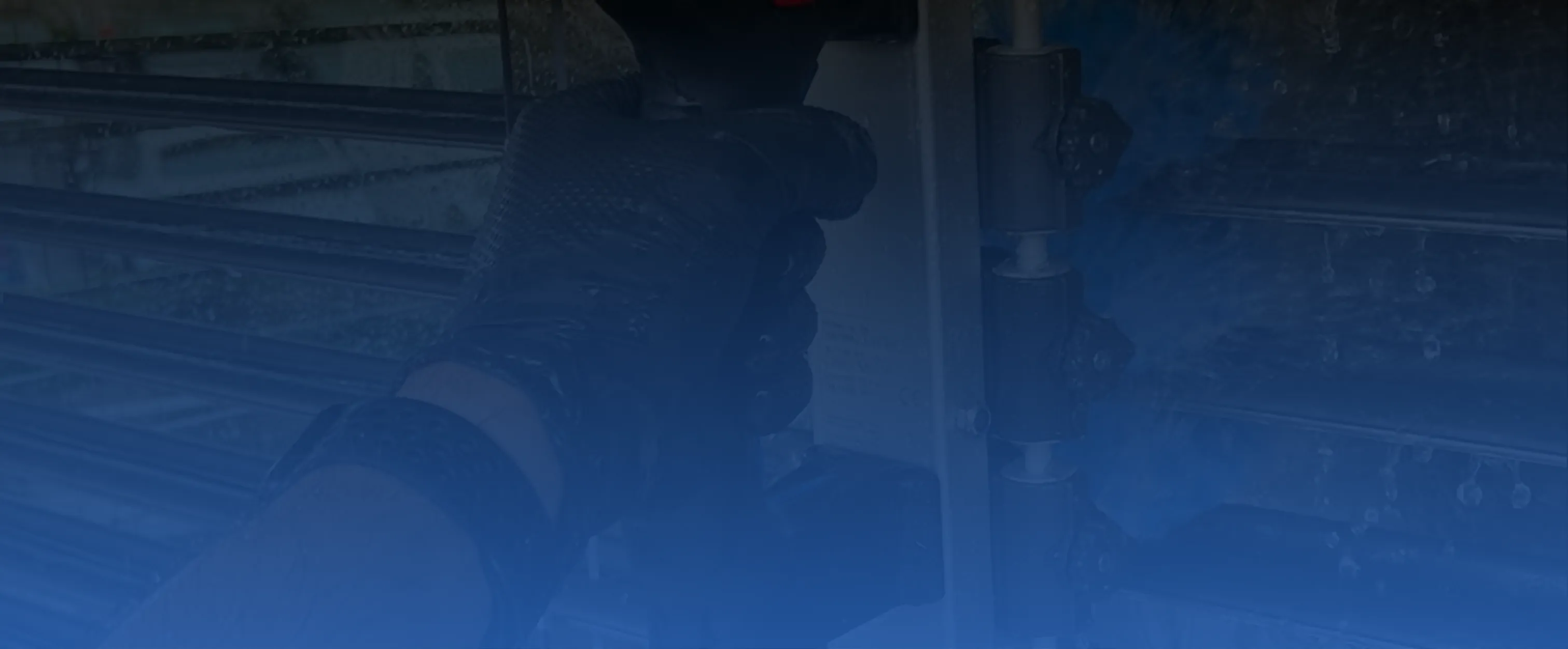 Hand mit Handschuh bedient Handgriff oder Hebel an metallener mechanischer Vorrichtung.