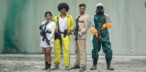 Four people standing side by side holding rifles, dressed in varied outfits including a white skirt and jacket, yellow tracksuit, beige suit, and green hazmat suit with a gas mask.