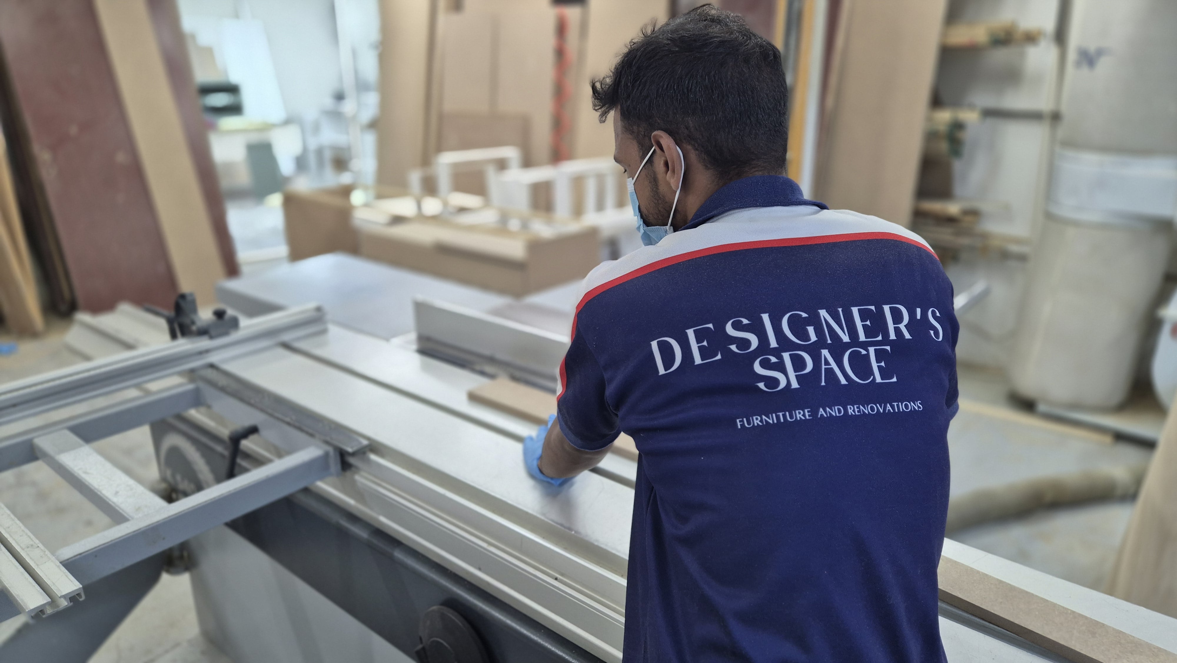 A modern kitchen with white cabinets, a large island with bar stools, and two pendant lights