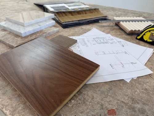 A cozy reading nook with a yellow armchair, a floor lamp, and a framed abstract print.