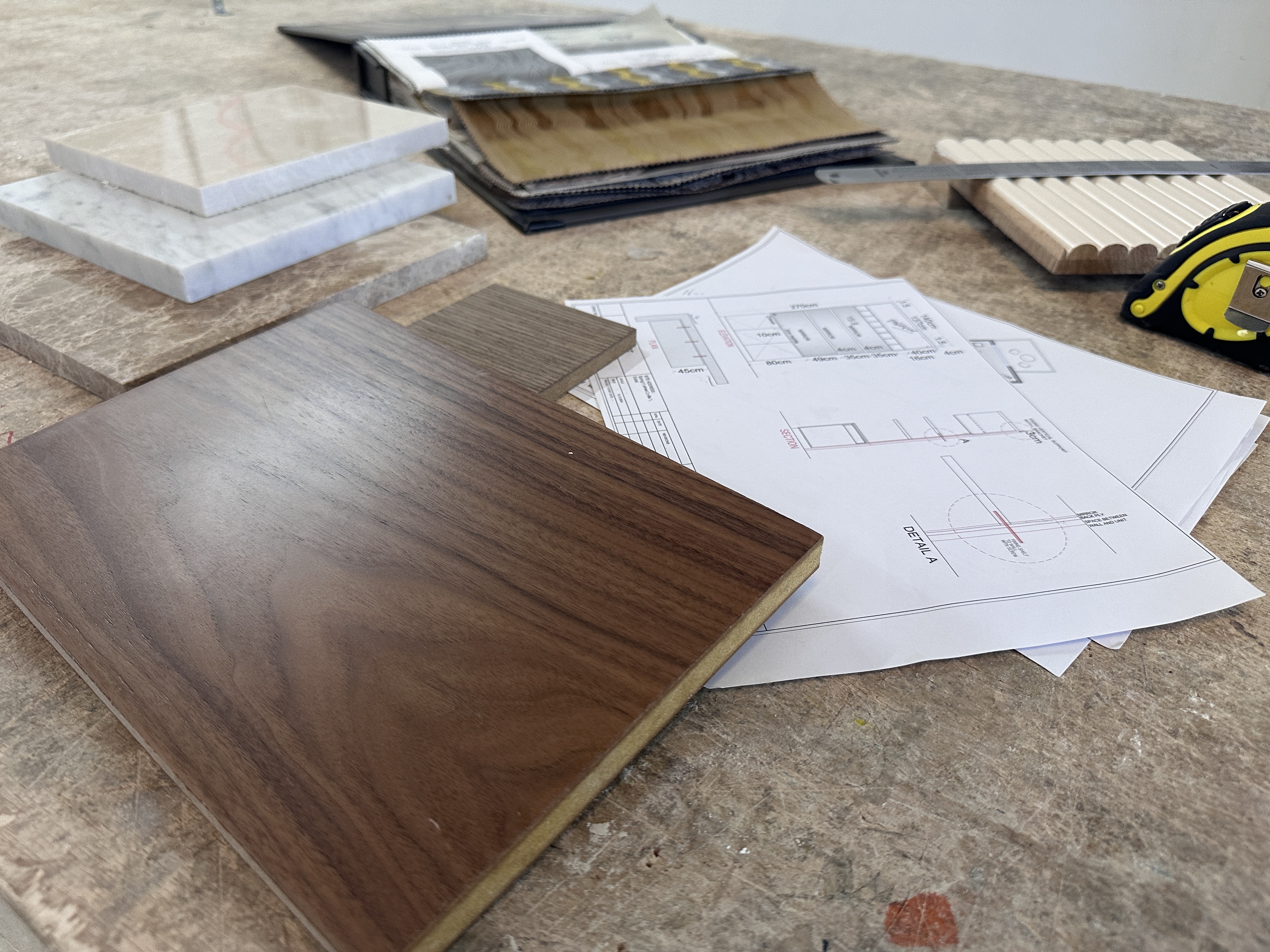 A cozy reading nook with a yellow armchair, a floor lamp, and a framed abstract print.