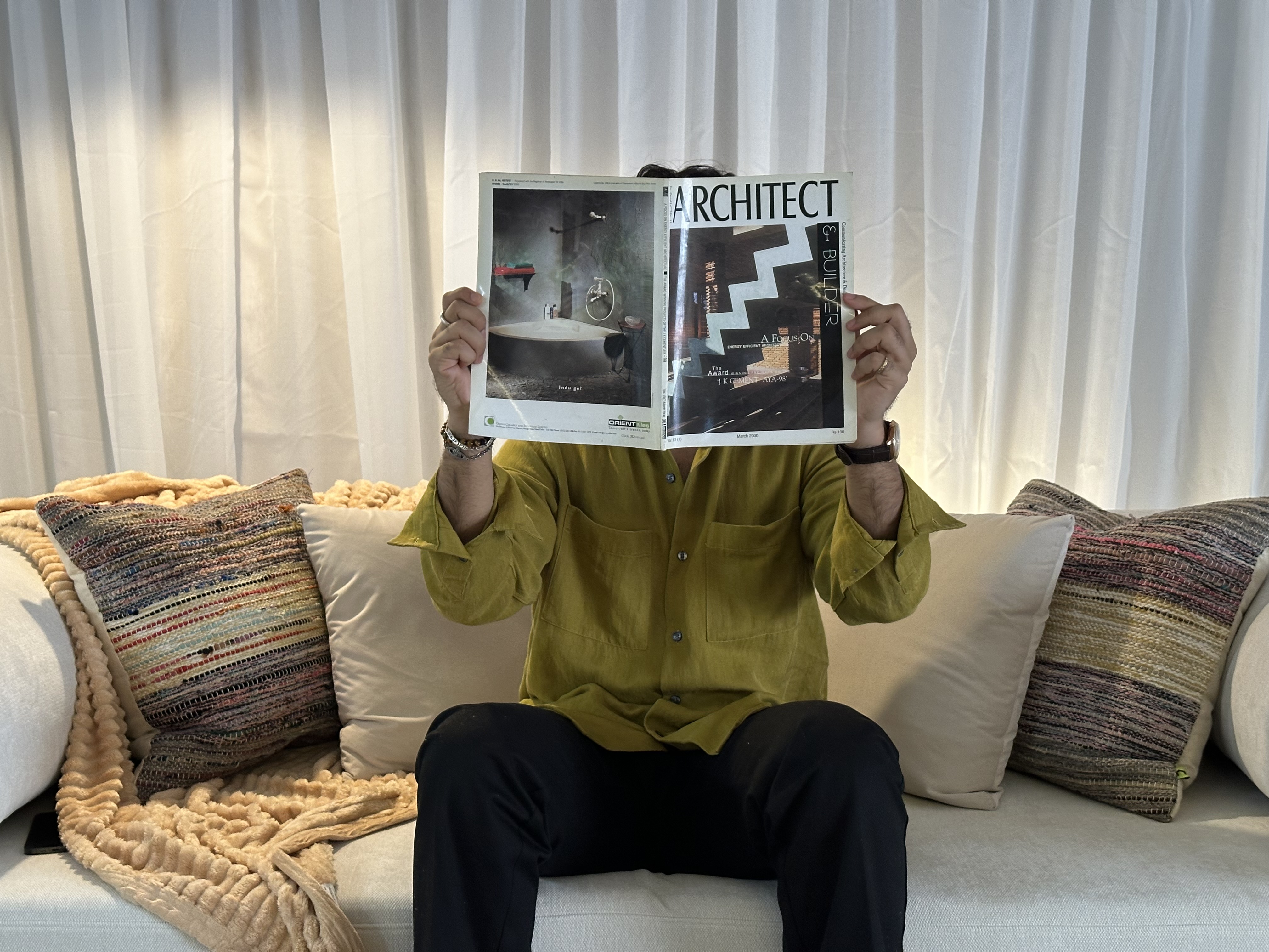 A minimalist home office with a desk, chair, computer, and a large plant.