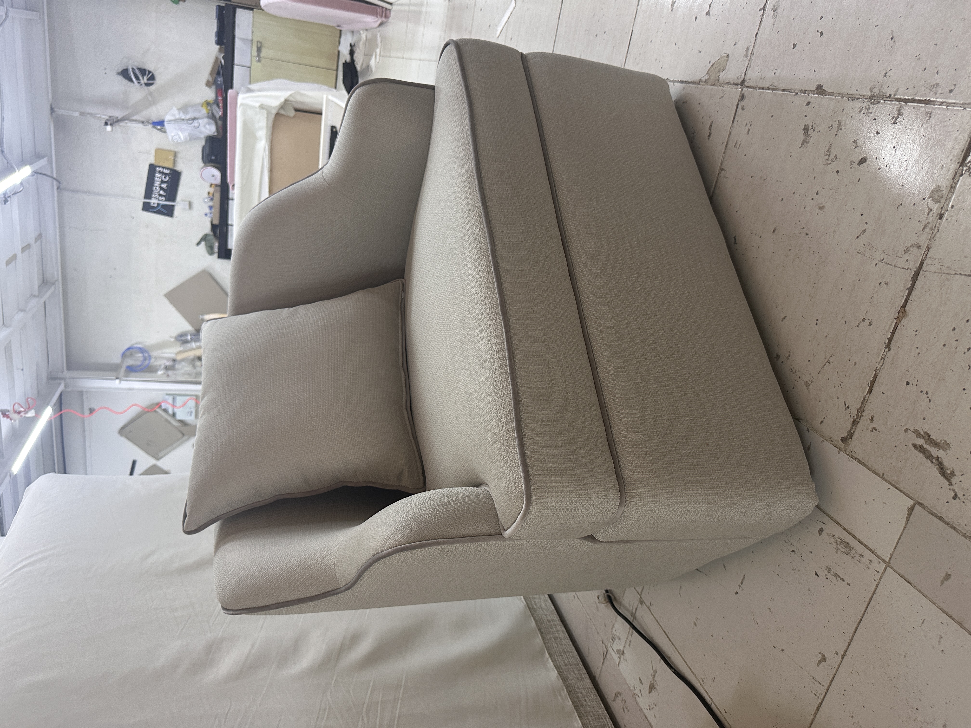 Modern dining room with large windows, a black and gold table, green and beige chairs, and a stylish chandelier above.